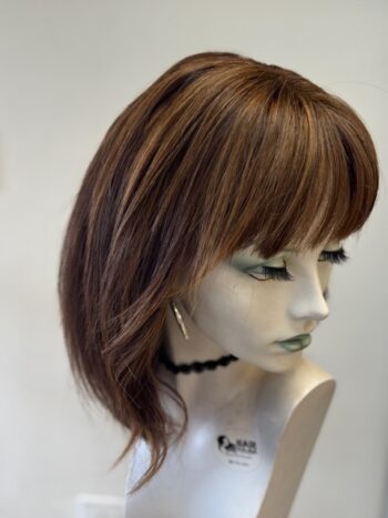 A mannequin with long hair and bangs on display.