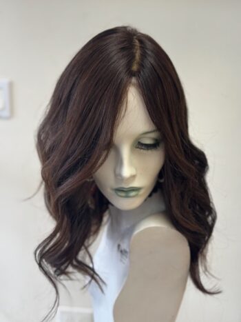 A mannequin head with long hair and a green face.