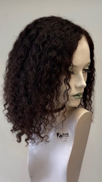 A mannequin head with long curly hair on it.