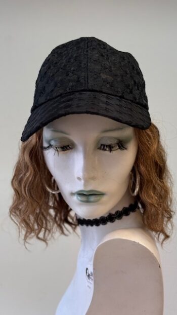 A mannequin wearing a black hat and necklace.