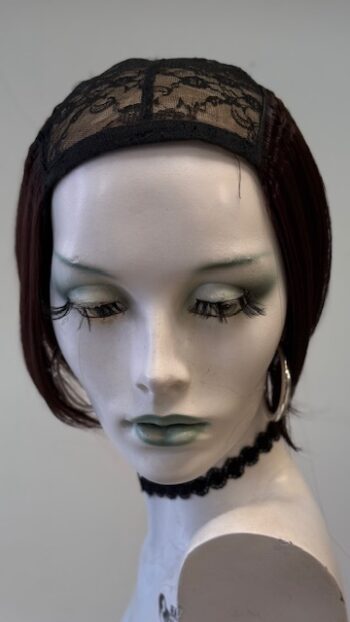 A mannequin head with green eyes and black hair.