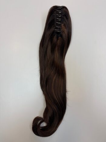 A long brown hair extension is hanging on the wall.