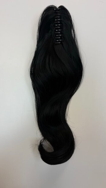 A black hair extension hanging on the wall.