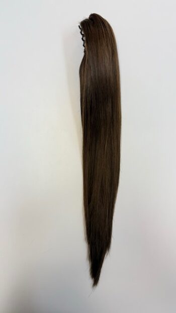 A long brown hair extension hanging on the wall.