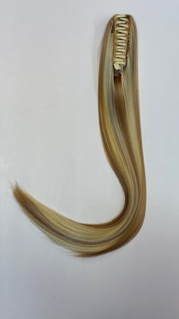 A long blonde hair extension hanging from the side of a wall.