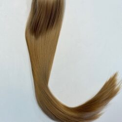 A long blond hair is bent over on the floor.