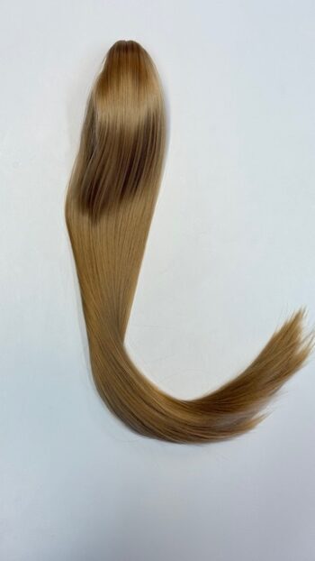 A long blond hair is bent over on the floor.