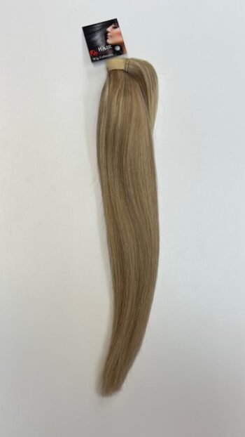 A blonde hair extension is hanging up on the wall.