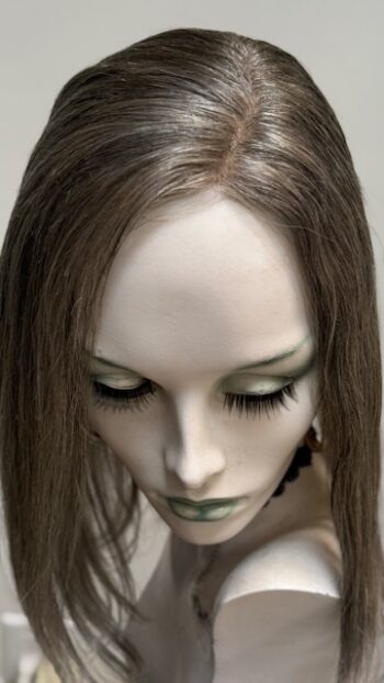 A close up of a doll head with long hair