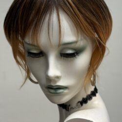 A mannequin with green eyes and black makeup.