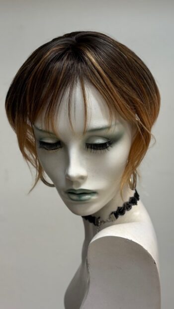 A mannequin with green eyes and black makeup.