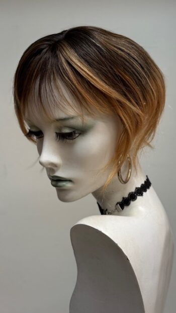 A mannequin with short hair and wearing jewelry.