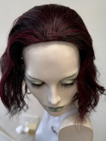 A mannequin head with red hair and green eyes.