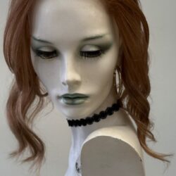 A mannequin with long red hair and black jewelry.