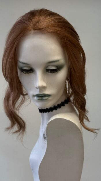 A mannequin with long red hair and black jewelry.