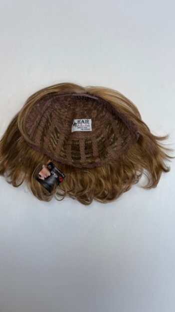 A wig is shown with hair in it.