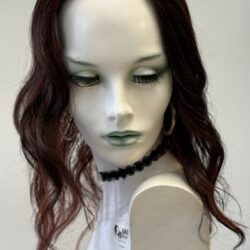 A mannequin with long red hair and black earrings.