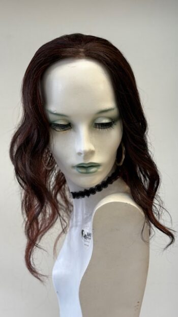 A mannequin with long red hair and black earrings.