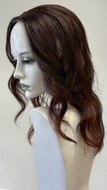 A mannequin head with long brown hair and green eyes.