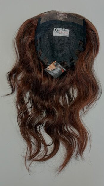 A wig hanging on the wall with its tag.