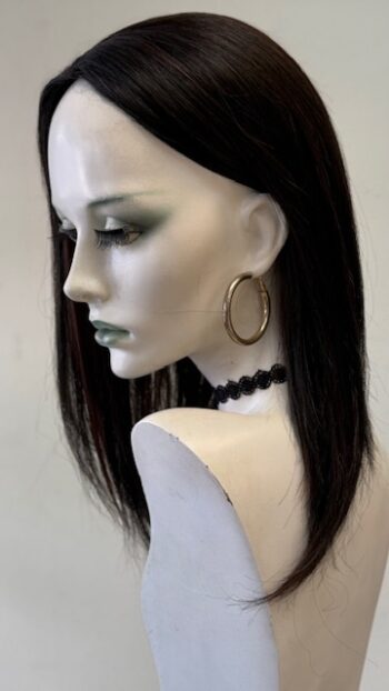 A mannequin wearing jewelry and a necklace.