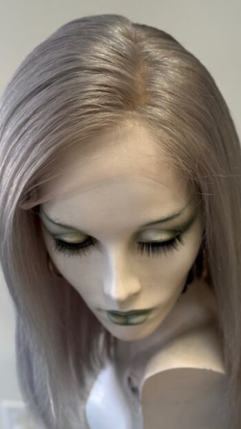 A close up of a doll head with long hair