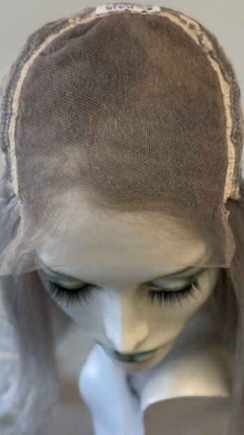 A mannequin with long eyelashes and a gray veil.