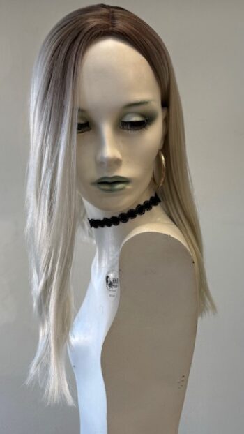 A mannequin wearing a white dress and black necklace.