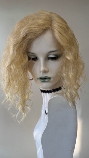 A mannequin with blonde hair and green eyes.