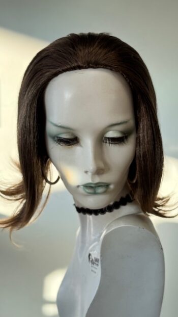 A mannequin with green eyes and black hair.