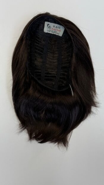 A black wig hanging on the wall