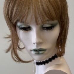 A mannequin with bangs and black jewelry.