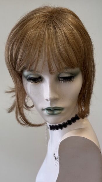 A mannequin with bangs and black jewelry.