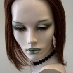 A mannequin with green eyes and black lipstick.