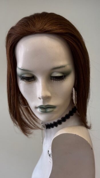 A mannequin with green eyes and black lipstick.