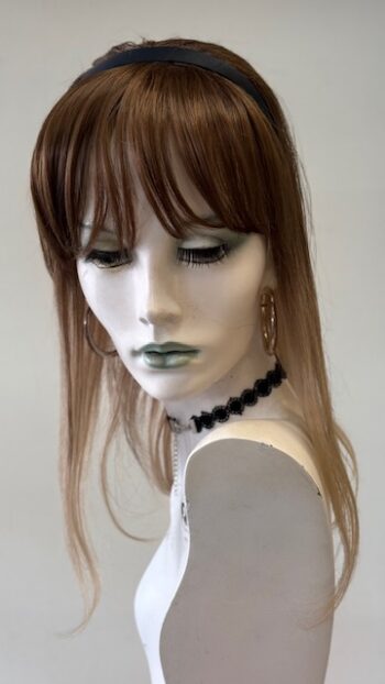 A mannequin with long hair and black jewelry.