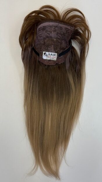 A wig is shown with long hair hanging on the wall.