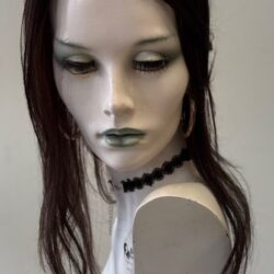 A mannequin with long black hair and green eyes.