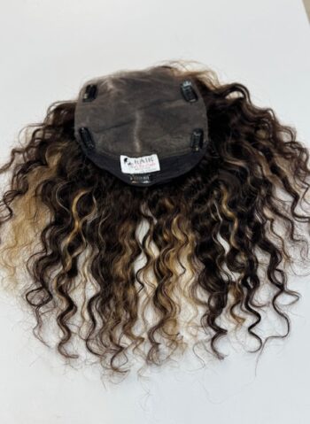 A wig with long hair is shown on the ground.