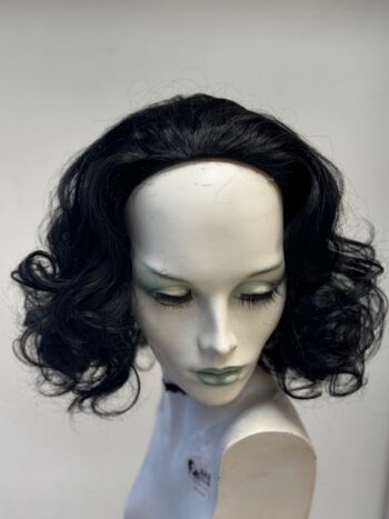 A mannequin head with black hair and green eyes.